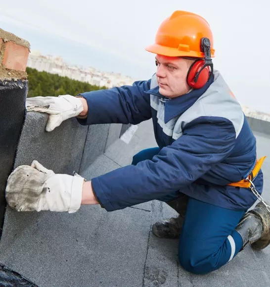 Crew performing commercial roof replacement on a large industrial building in Illinois